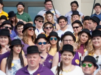 A group of students wearing black hats and holding canes