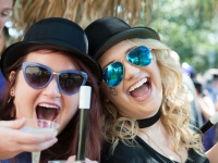 Two female students wearing black hats smile for a photo