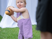 A baby tries to throw a football