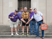 A group of people smile for a photo while touching a black and gold cane